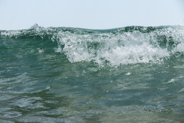 Vue rapprochée de la vague de mer avec mousse et ciel bleu en arrière-plan
  - Photo, image