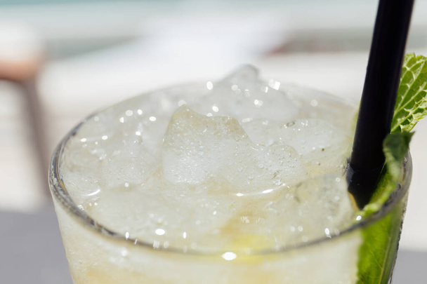 Selective focus of glass of cocktail with ice cubes and mint leaf - Zdjęcie, obraz