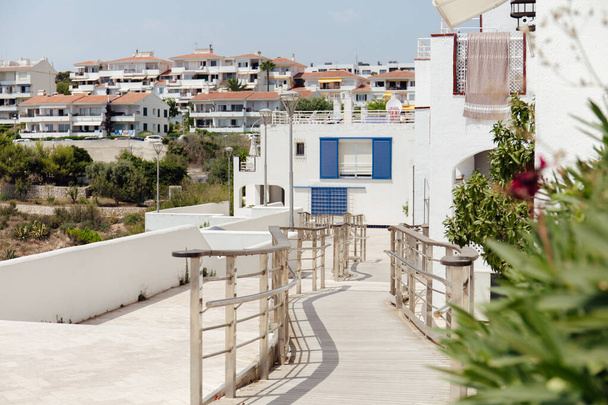 Foco selectivo de pasarela con barandilla en calle urbana con casas en Cataluña, España
  - Foto, imagen