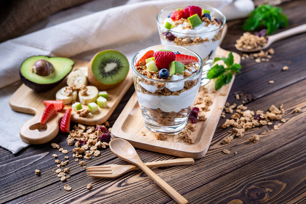 Řecký jogurt domácí s bobulemi, avokádem, banánem a granolou. Je to zdravé menu a nízké kalorie pro lidi, kteří dietu. vysoce kvalitní obraz pro umělecká díla a grafický design - Fotografie, Obrázek
