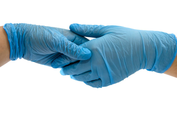 Aperto de mão com luvas médicas azuis, visão de perfil em fundo branco
. - Foto, Imagem