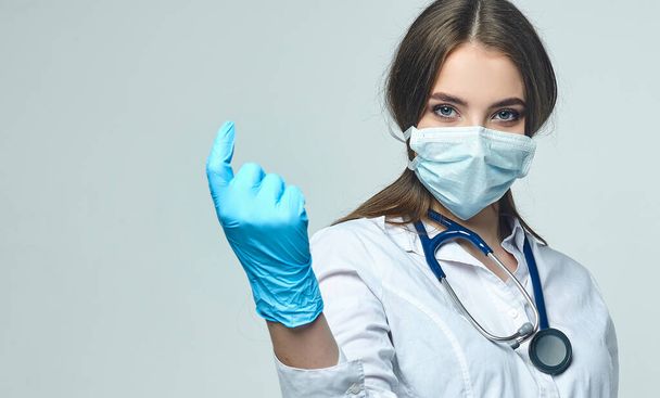 Covid19, coronavirus, a concept of healthcare and doctors. Portrait of a female doctor wearing a medical mask to prevent infection with the virus - Photo, image
