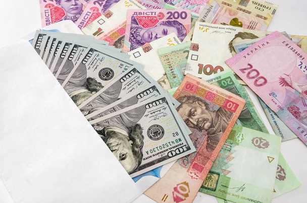 Dólares em um envelope branco e hryvnias diferentes. Conceito de negócio
. - Foto, Imagem