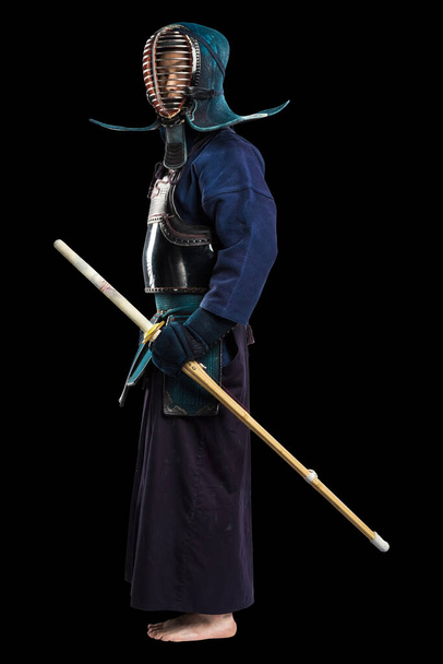 Shinai (bambu kılıcı) ile insan kendo dövüşçüsü portresi. Stüdyoda çekilmiş. Siyah arkaplanda kırpma yolu ile izole edildi - Fotoğraf, Görsel