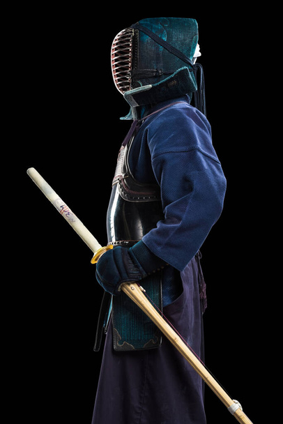竹刀を手にした剣道人の肖像画。スタジオで撃たれた。黒の背景にクリッピングパスで隔離された - 写真・画像