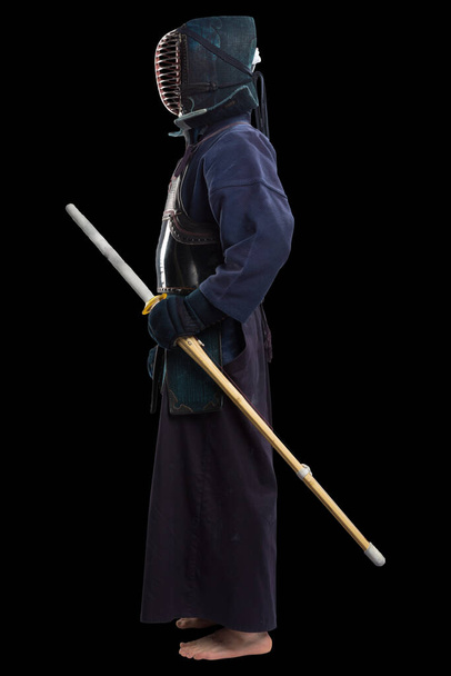Porträt eines Kendo-Kämpfers mit Shinai (Bambusschwert). Gedreht im Studio. Isoliert mit Clipping-Pfad auf schwarzem Hintergrund - Foto, Bild