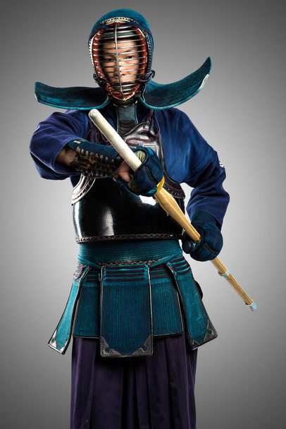 Portrét muže kendo bojovníka se shinai (bambusový meč). Zastřelen ve studiu. Izolováno s oříznutou cestou na šedém pozadí - Fotografie, Obrázek