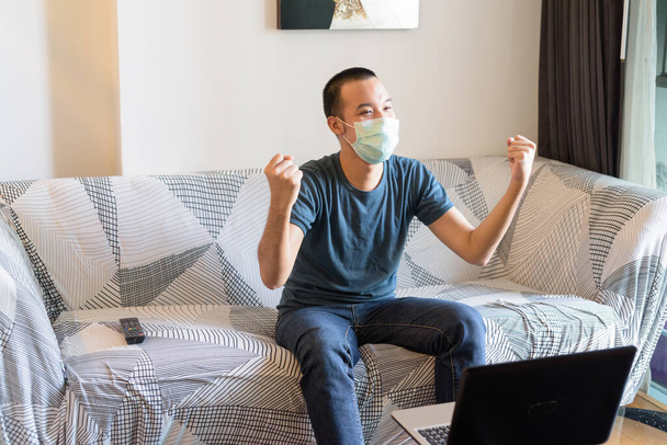 Πορτρέτο του νεαρού Ασιάτη με μάσκα προστασίας από το ξέσπασμα του ιού της κορώνας που μένει στο σπίτι υπό καραντίνα - Φωτογραφία, εικόνα