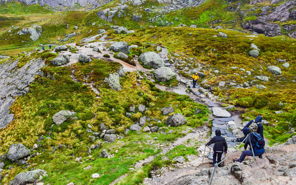 Цепи на пути к знаменитому Kjeragbolten помочь туристам подняться крутые скалы. Кьерагболтен - скала, застрявшая между двумя горами над Люзеорденом на горе Фаг в муниципалитете Форсанд, Норвегия.
. - Фото, изображение