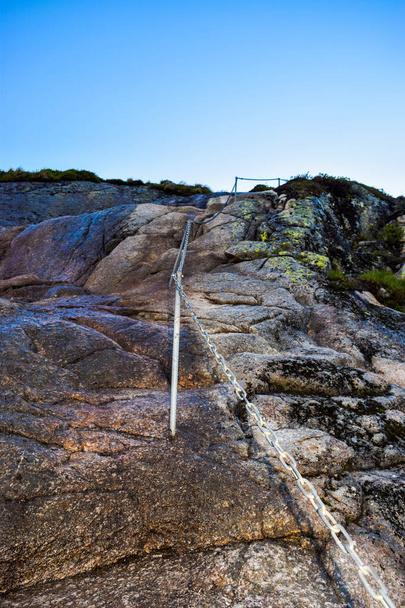Chains on pathway to famous Kjeragbolten to help go up on climb steep cliffs. Kjeragbolten is a rock stuck between two mountains above Lysefjorden on mountain Kjerag in Forsand municipality, Norway. - Photo, Image
