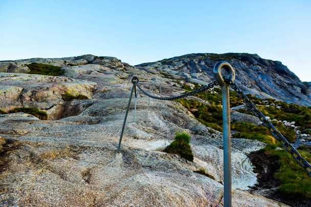 有名なKjeragboltenへのパス上のチェーン急な崖を登るに行くのを助けるために。Kjeragboltenは、ノルウェーのForsand自治体の山KjeragのLysefordenの上の2つの山の間に挟まれた岩です。. - 写真・画像