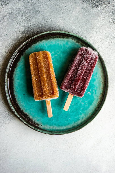 Organic fruit dessert frozen popsicles on the plate - Фото, зображення