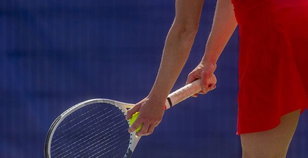 女のクローズアップはハードテニスコートでテニスラケットを保持しています - 写真・画像