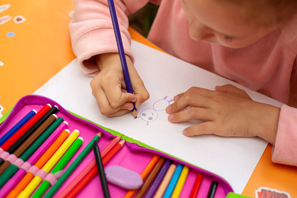 kleines Mädchen zeichnet mit Buntstiften auf Papier - Foto, Bild