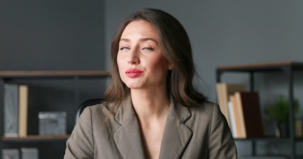 Close up face of young Caucasian beautiful woman turning face to camera and smiling in office. Portrait of pretty successful businesswoman with smile. Female working in cabinet. - Filmagem, Vídeo