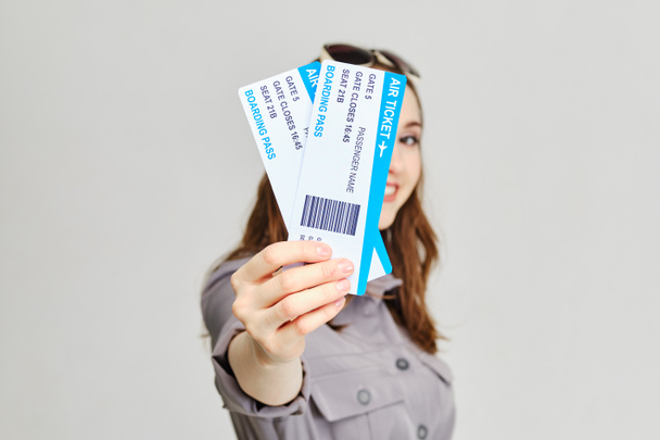 Girl holds forward plane tickets with a smile. Close up. - Foto, Bild