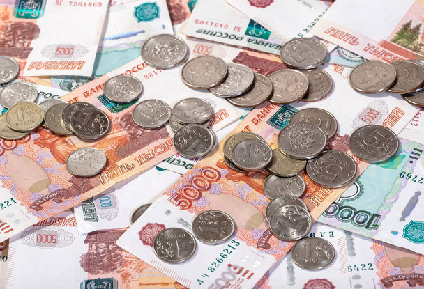 Фон банкнот рублів, що лежать на поверхні з великою кількістю монет
 - Фото, зображення