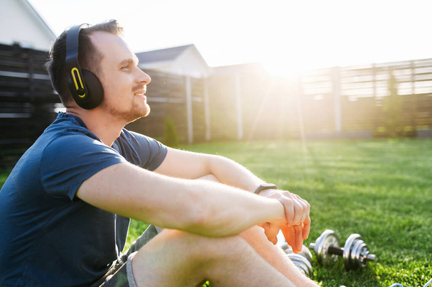 A young attractive athletic guy in headphones - Photo, Image
