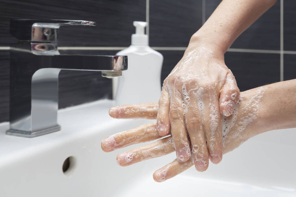 Kobieta myje ręce mydłem. Nierozpoznawalna kobieta pokazująca jak prawidłowo myć ręce. Zapobieganie koronawirusowi lub COVID-19 - Zdjęcie, obraz