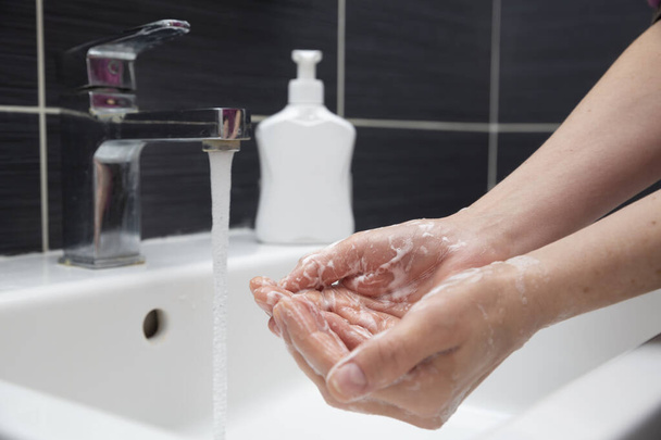Mujer lavándose las manos con jabón. Una hembra irreconocible que muestra cómo lavarse las manos correctamente. Prevención del Coronavirus o COVID-19
 - Foto, Imagen