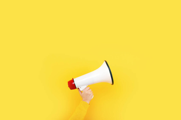 megaphone στο χέρι σε κίτρινο φόντο, διαφημιστική έννοια - Φωτογραφία, εικόνα