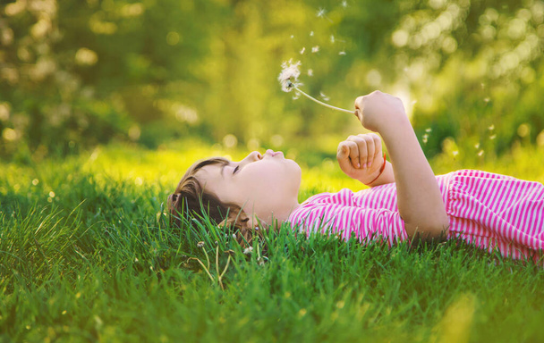 Κοριτσάκι με πικραλίδες στο πάρκο. Επιλεκτική εστίαση. - Φωτογραφία, εικόνα