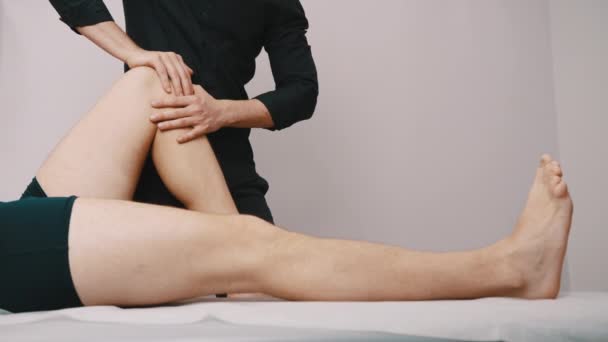Physiotherapie. Techniker inspiziert die Flexibilität des Knies - Filmmaterial, Video