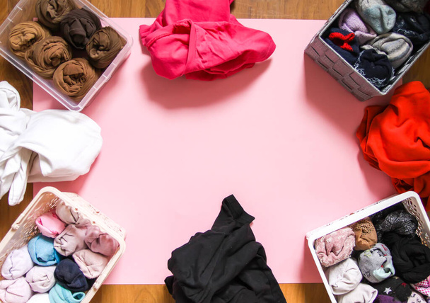 Barevné oblečení vertikální skladování v domácí skříni. Různé oděvní předměty v plastových a textilních krabicích. - Fotografie, Obrázek