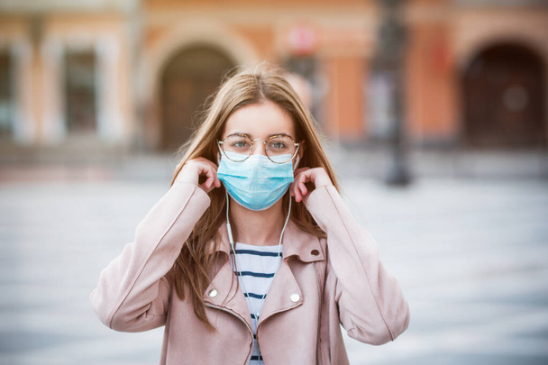 Молодая женщина носит медицинскую маску для защиты от загрязнения, микробов и коронавируса
 - Фото, изображение