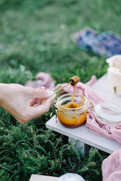 female hands hold a spoon in caramel. garden picnic birthday celebration - Photo, Image