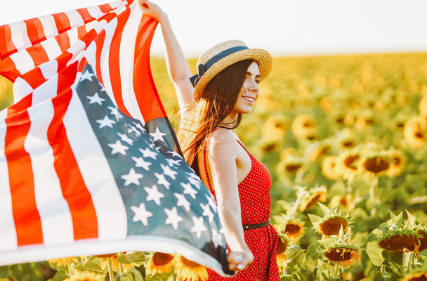 4th of July. Amazing girl in hat with the American flag in a sunflower field. Freedom day. Sunset light. Independence Day. Patriotic concept - Fotografie, Obrázek