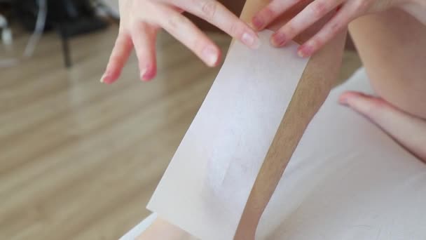 woman hands stick a depilation strip on hairy leg and remove it from skin  - Záběry, video