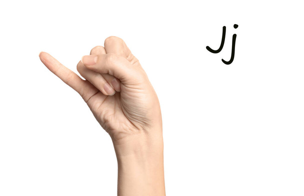 Woman showing letter J on white background, closeup. Sign language - 写真・画像