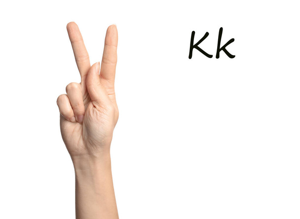 Γυναίκα που δείχνει το γράμμα Κ σε λευκό φόντο, κοντινό πλάνο. Νοηματική γλώσσα - Φωτογραφία, εικόνα