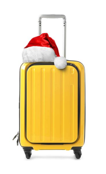 Stylish suitcase with Santa Claus hat isolated on white. Christmas vacation  - Photo, image