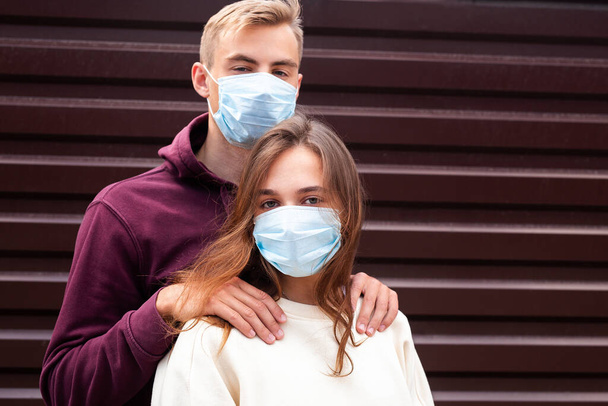 Two people in masks hugging.Couple being divided by incurable infectious disease - Fotoğraf, Görsel