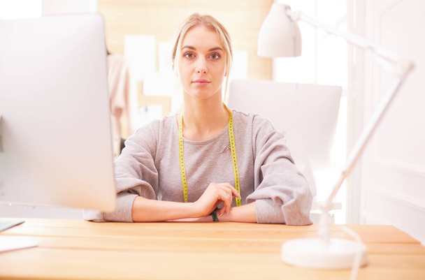 Fashion designer woman working in studio, sitting at thhe desk - Φωτογραφία, εικόνα