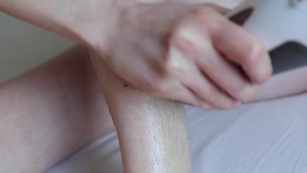 woman hands apply wax on hairy leg, stick a depilation strip and remove it from skin  - Imágenes, Vídeo
