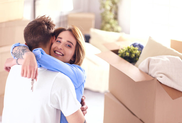 Young happy couple hugging, showing keys to new house - Φωτογραφία, εικόνα