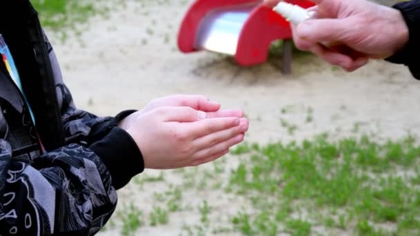 Ребенок дезинфицирует руки на детской площадке. Обработка вручную. Карантин KOVID-19
 - Кадры, видео