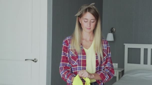 Junge Hausfrau zieht gelbe Handschuhe an - Filmmaterial, Video