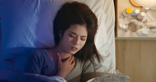 Top view of asian woman sick and has sore throat in the bedroom - Foto, imagen