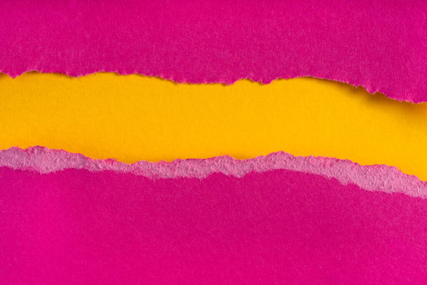 Kawałki podartego purpurowego papieru na żółtym tle. Pęknięta krawędź papieru odizolowana miękkim cieniem. Kawałek papieru rozdarty krawędź. Przestrzeń kopiowania, ramka, baner - Zdjęcie, obraz