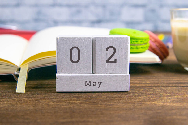2. Mai auf dem hölzernen Kalender. Der zweite Tag des Frühlingsmonats, ein Kalender am Arbeitsplatz. Frühling. Nahaufnahme. - Foto, Bild