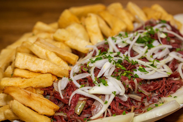 Beef jerky , with onion and fried cassava, traditional Brazilian food. close up. - Photo, Image