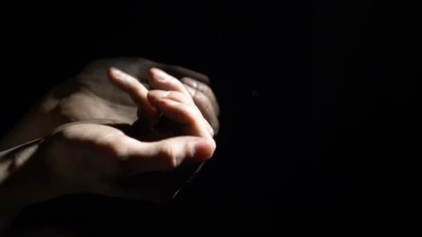 Euromunten vallen in de vuile handen van een man, een arbeider vertelt geld op een zwarte achtergrond in de duisternis - Video