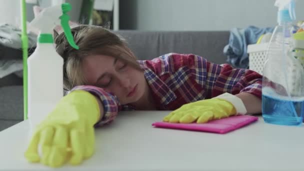 Mulher cansada usando uma esponja rosa para remover o pó da mesa
 - Filmagem, Vídeo