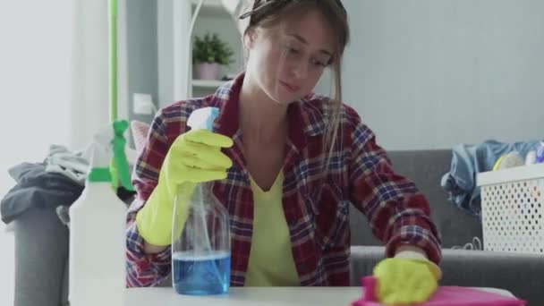 Tired woman using a pink sponge to trying hard removing dust from the table - Footage, Video