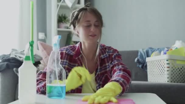 Attraktive junge Frau lustige Haushälterin hat Spaß beim Abstauben Tisch. - Filmmaterial, Video