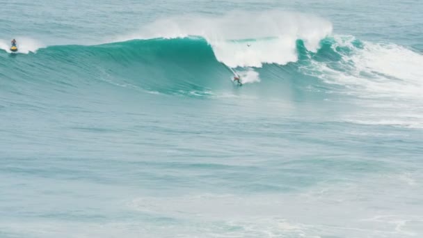 surfař v záchranných vestách rolky na vlně v Portugalsku, instruktor a dron doprovází, zpomalený pohyb - Záběry, video